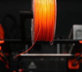 Orange filament spool on the printer