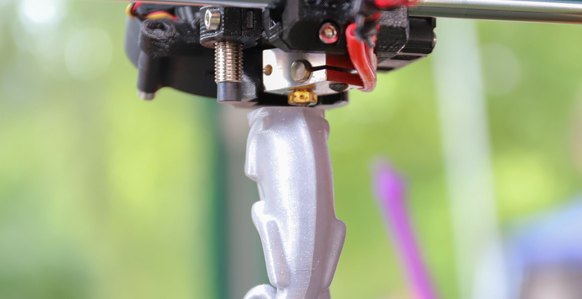 3D printer finishing a silver figurine