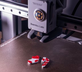 Red and white 3D printed ornaments on the build plate